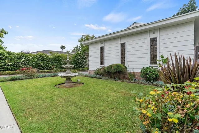 a backyard of a house with plants and outdoor seating