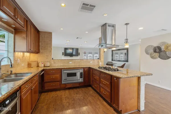 a kitchen with stainless steel appliances granite countertop a sink stove and refrigerator