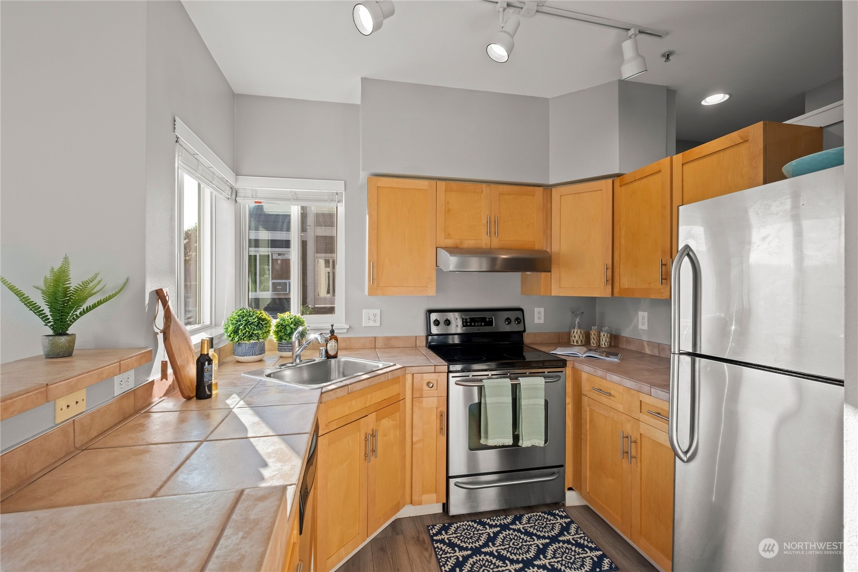 3914 243rd Place Southeast, Unit L203 Bothell, WA 98021 - Photo 11 of 32 a kitchen with stainless steel appliances a refrigerator sink and stove