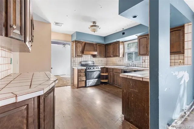 a kitchen with stainless steel appliances granite countertop a sink stove and refrigerator