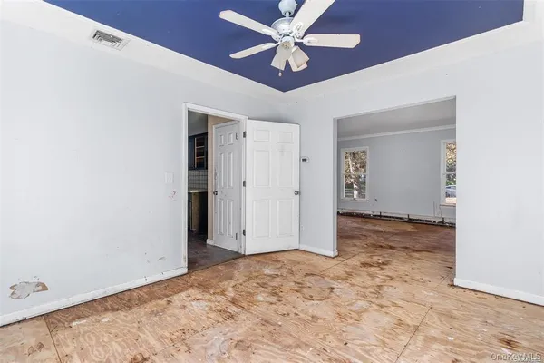 an empty room with closet and a ceiling fan