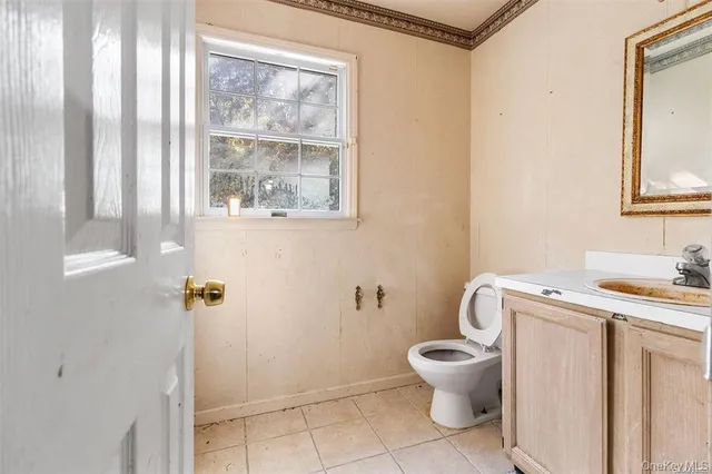 a bathroom with a granite countertop toilet a sink and a mirror