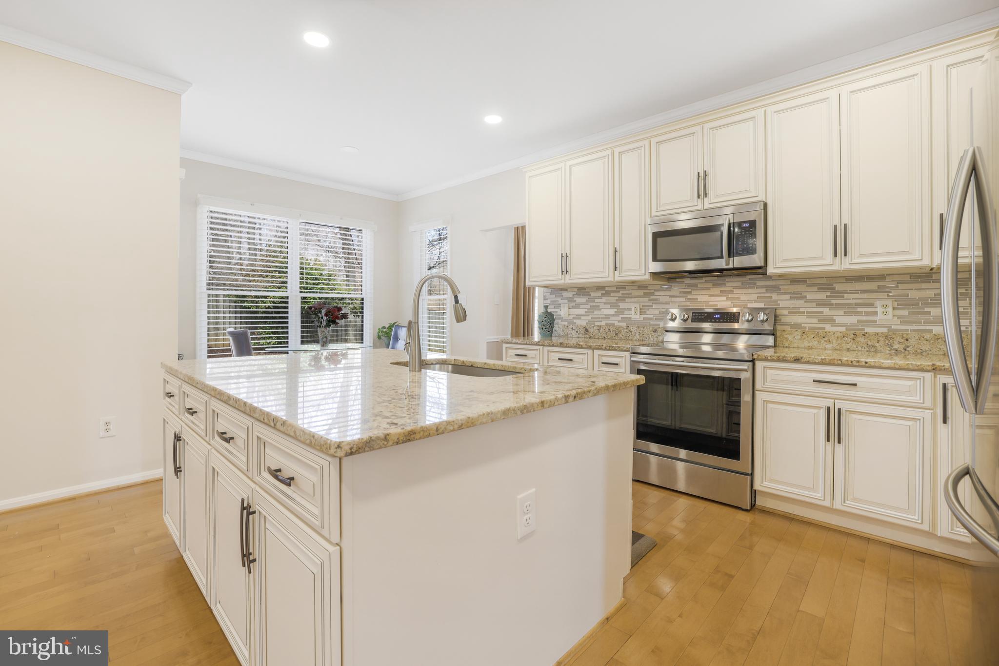 15532 Quince Ridge Lane North Potomac, MD 20878 - Photo 7 of 50 a kitchen with stainless steel appliances granite countertop a stove a sink dishwasher a microwave oven and a refrigerator with wooden floor