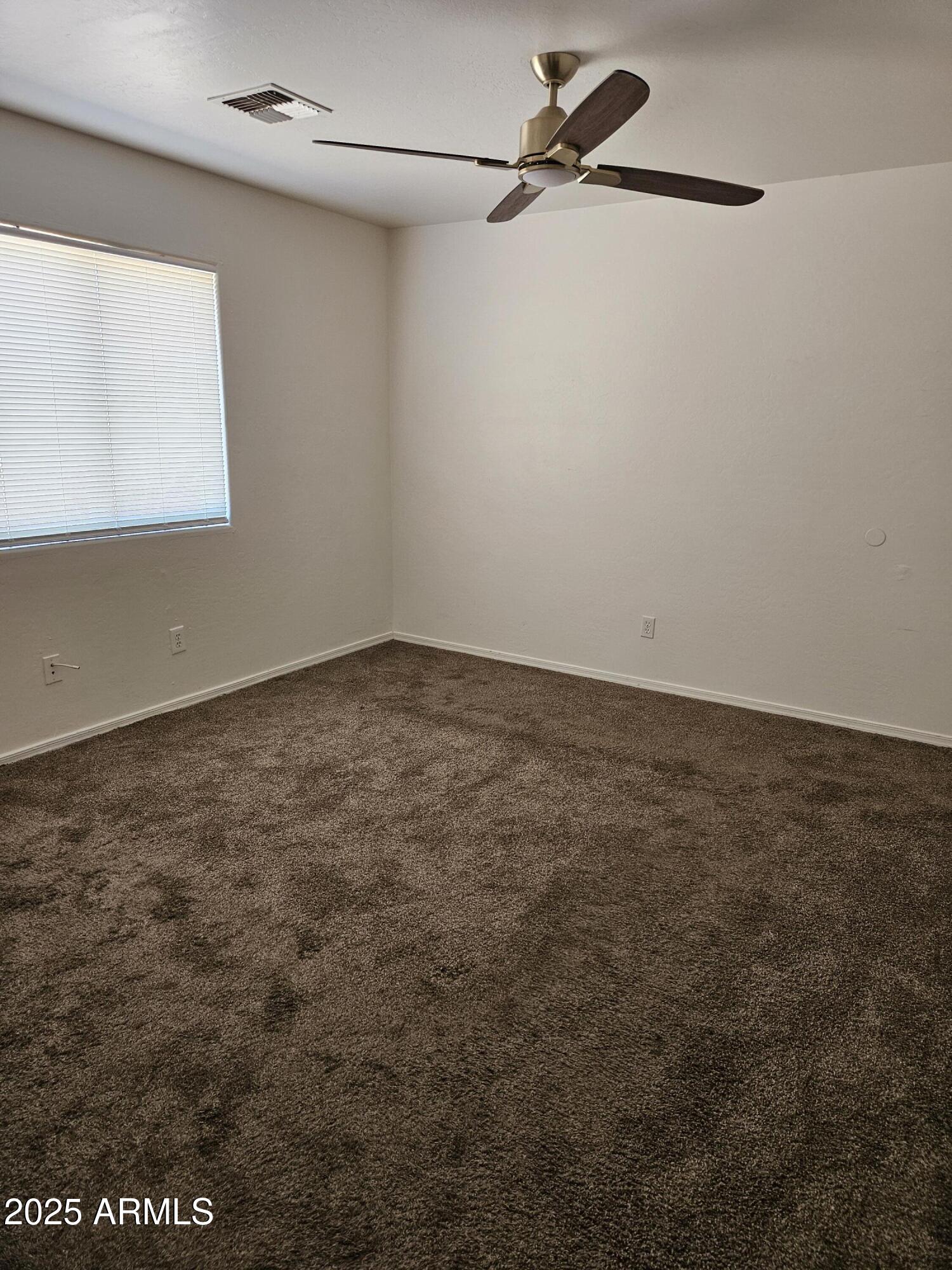 15676 South Moon Valley Road, Unit 2 Arizona City, AZ 85123 - Photo 3 of 5 an empty room with a ceiling fan and a window