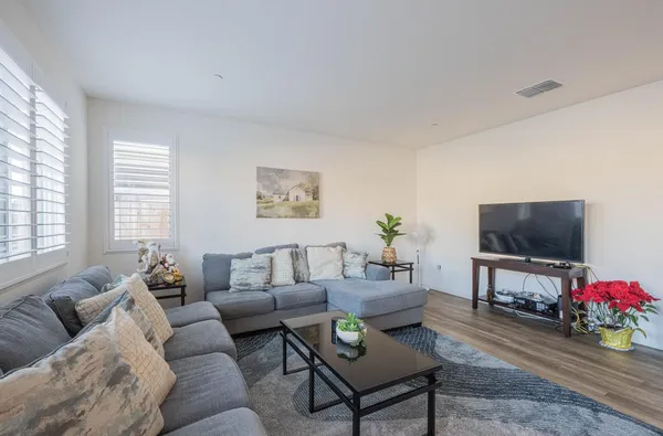 a living room with furniture a flat screen tv and a window
