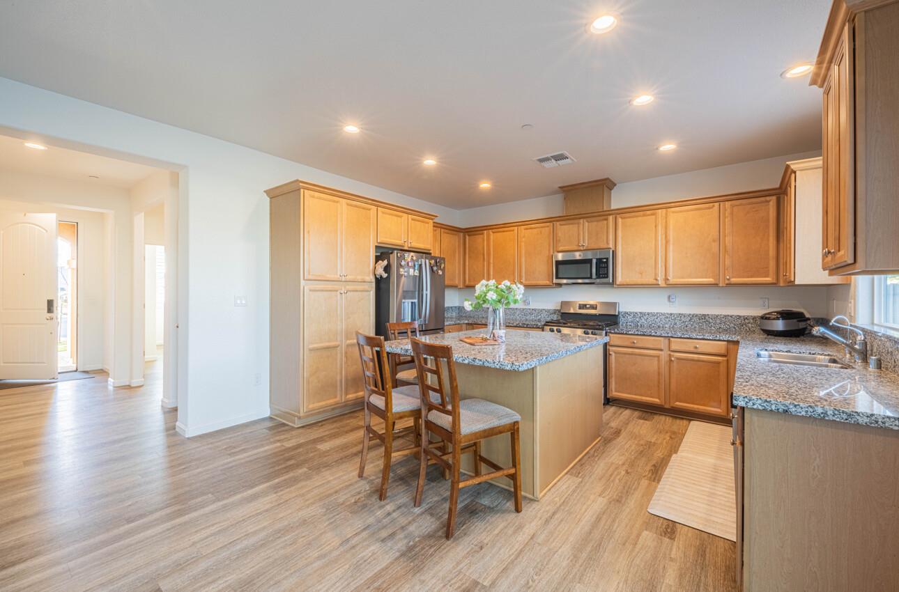 570 Tankersley Street Soledad, CA 93960 - Photo 15 of 64 a kitchen with stainless steel appliances granite countertop a refrigerator a stove top oven a sink dishwasher and white cabinets with wooden floor