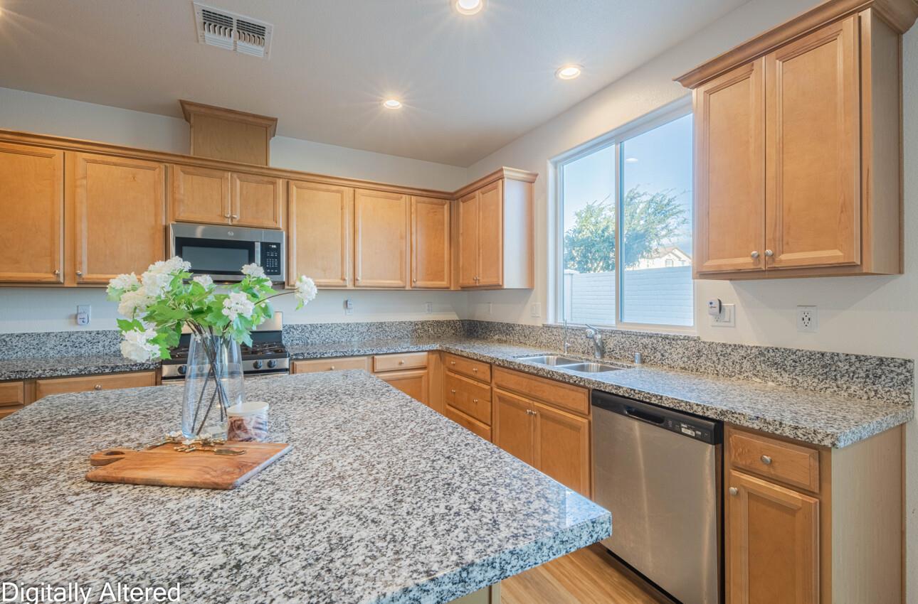570 Tankersley Street Soledad, CA 93960 - Photo 16 of 64 a kitchen with granite countertop a sink a window and a counter top space