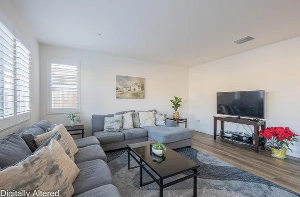 a living room with furniture a flat screen tv and a window