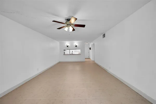 a view of empty room with ceiling fan