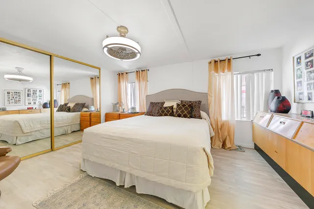 a bedroom with a bed and a painting on the wall