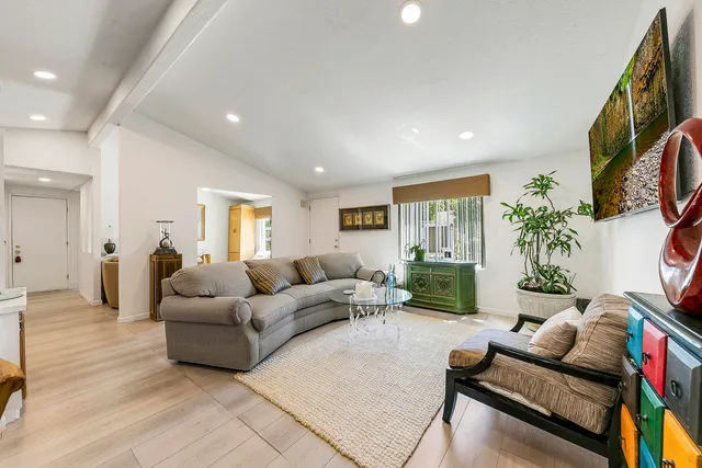 a living room with furniture and view of kitchen