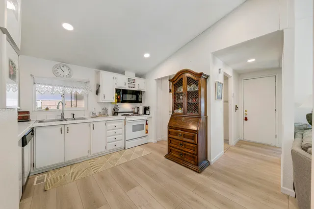 a kitchen with white cabinets stainless steel appliances and sink