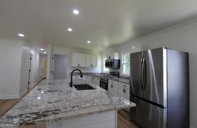 a kitchen with kitchen island a counter top space cabinets and stainless steel appliances
