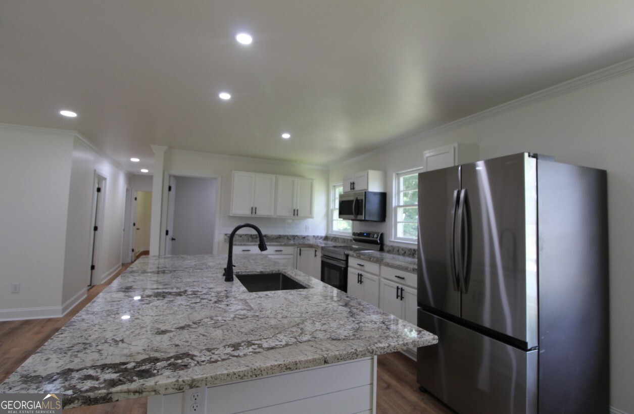 8142 Alabama Highway Rome, GA 30165 - Photo 3 of 10 a kitchen with kitchen island a counter top space cabinets and stainless steel appliances