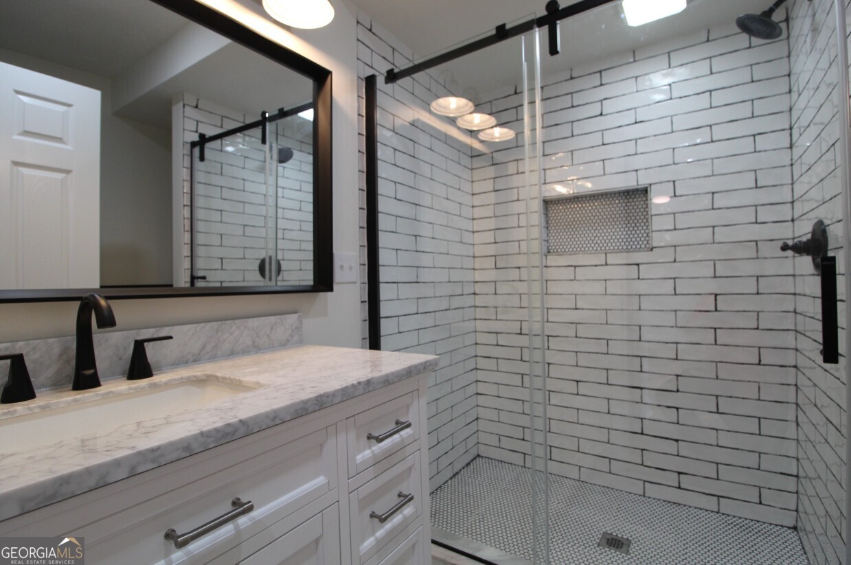 8142 Alabama Highway Rome, GA 30165 - Photo 5 of 10 a bathroom with a sink a toilet a mirror and shower