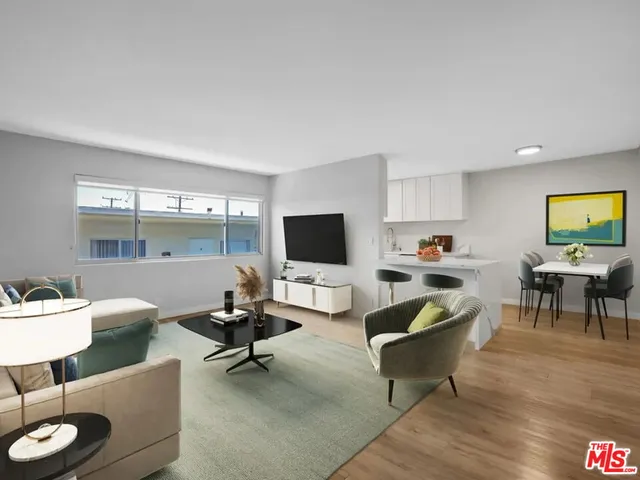 a living room with furniture and a flat screen tv with wooden floor