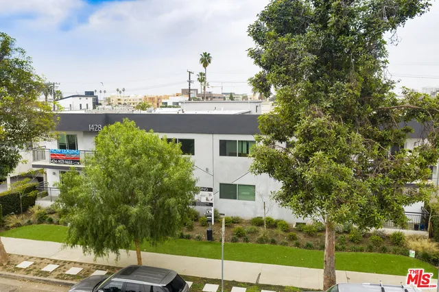 a view of a house with a yard and potted plants