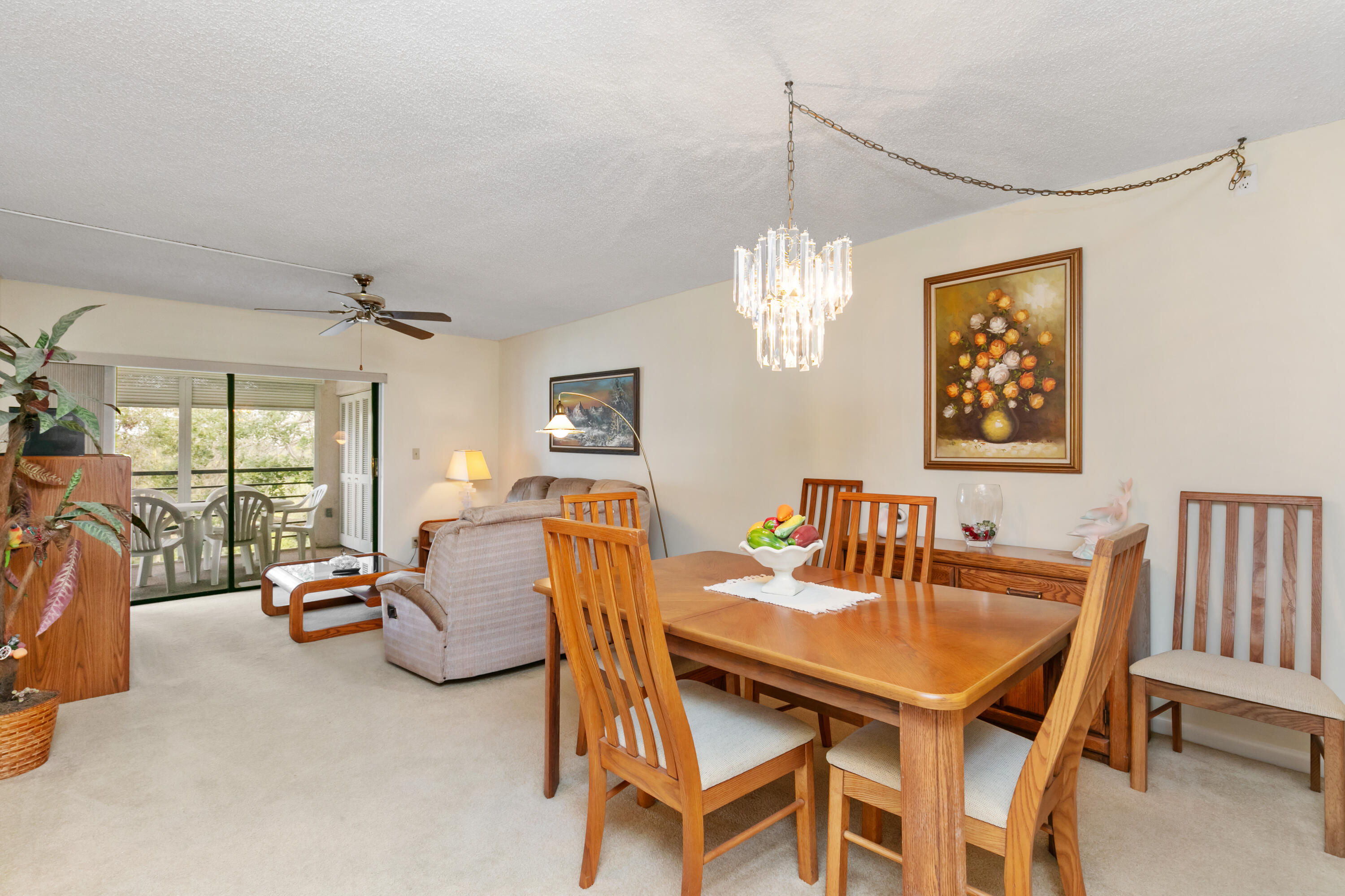 9235 Southwest 8th Street, Unit 407 Boca Raton, FL 33428 - Photo 1 of 24 a dining room with furniture a chandelier and window