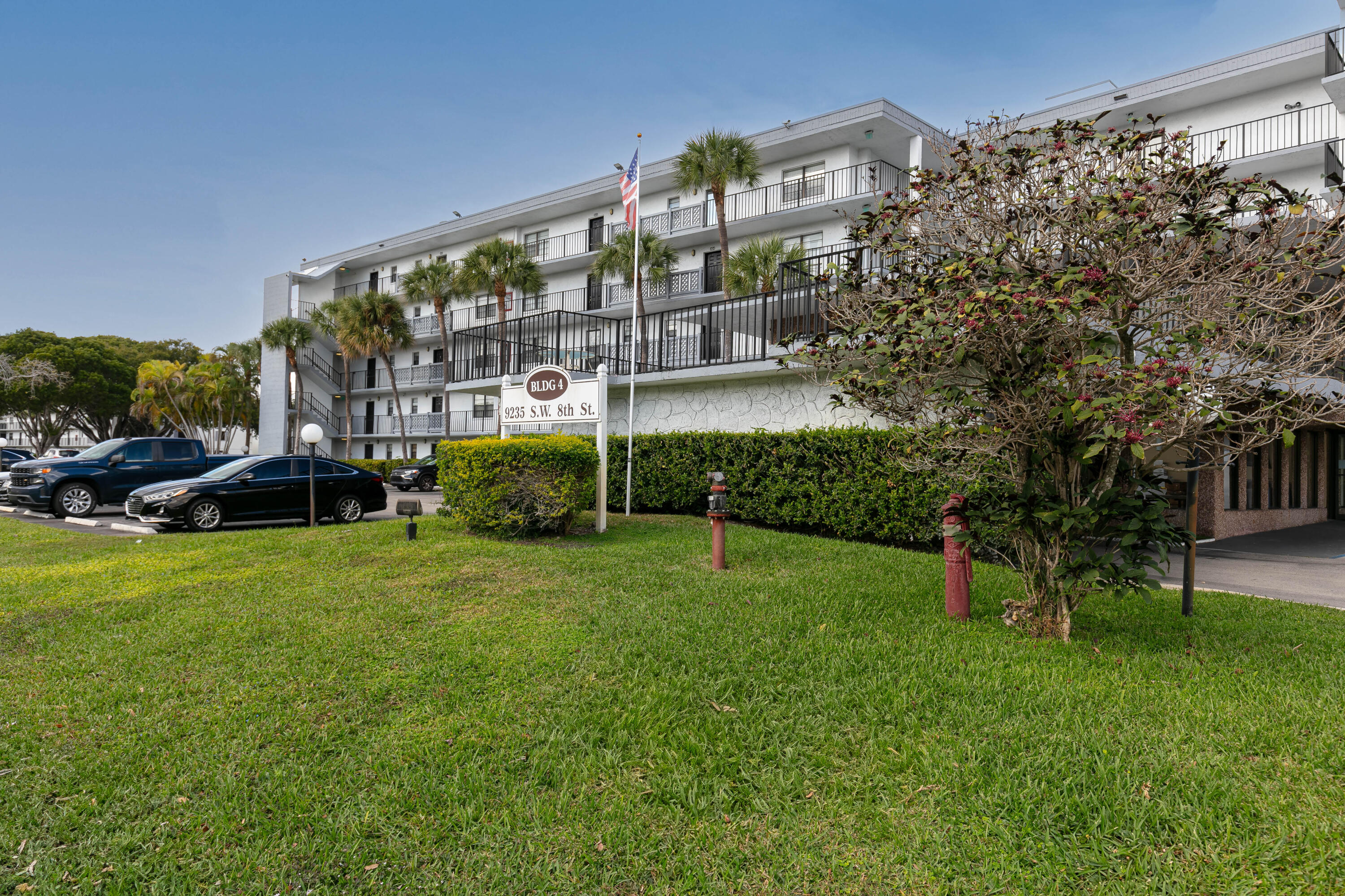 9235 Southwest 8th Street, Unit 407 Boca Raton, FL 33428 - Photo 23 of 24 a view of a big yard and front view of building