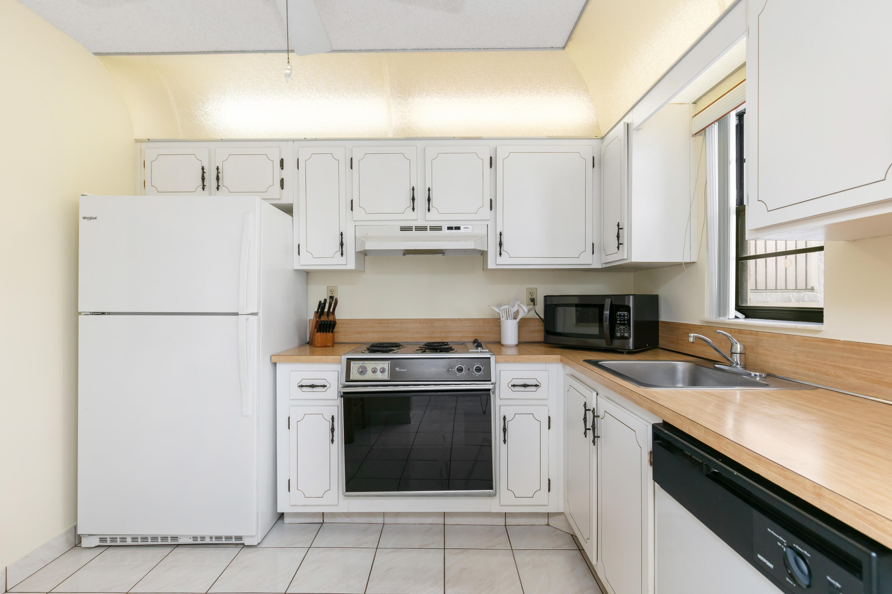 9235 Southwest 8th Street, Unit 407 Boca Raton, FL 33428 - Photo 6 of 24 a kitchen with cabinets appliances and a sink