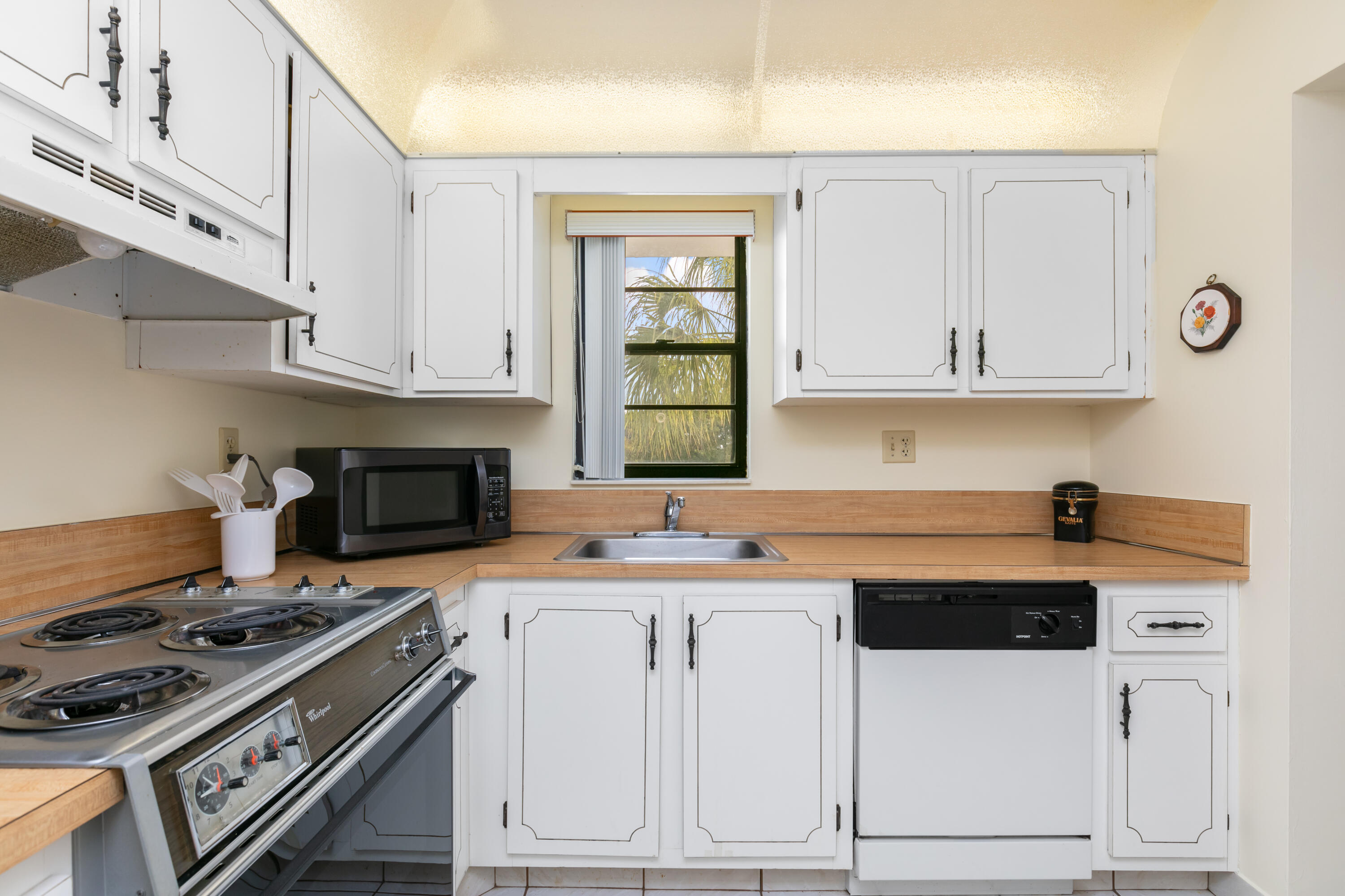 9235 Southwest 8th Street, Unit 407 Boca Raton, FL 33428 - Photo 8 of 24 a kitchen with white cabinets and appliances