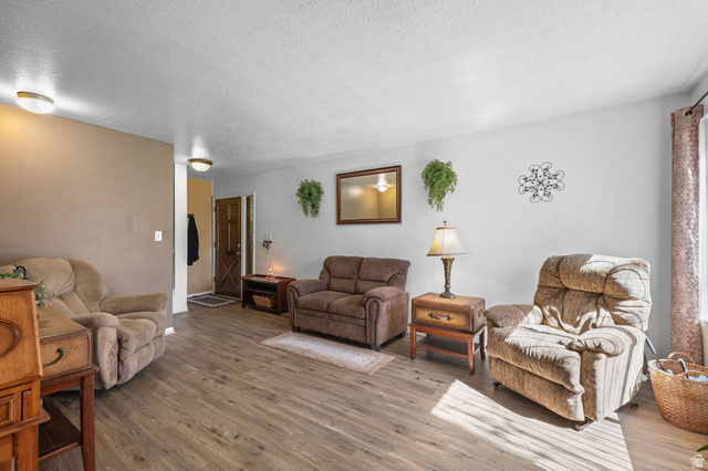 1120 Canyon Road, Unit 38 Ogden, UT 84404 - Photo 8 of 24 Living area with wood finished floors and a textured ceiling