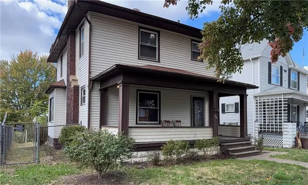 a view of a house with brick walls and a large tree