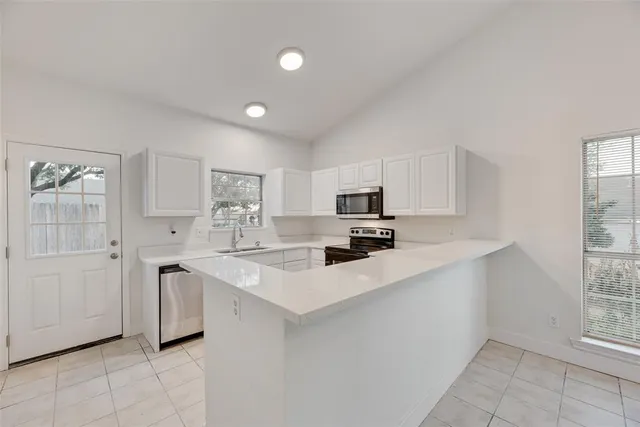 a kitchen with stainless steel appliances a sink stove and cabinets