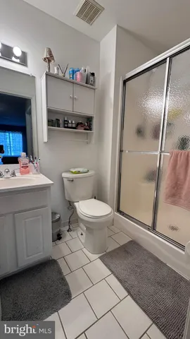 a bathroom with a sink a toilet a mirror and shower