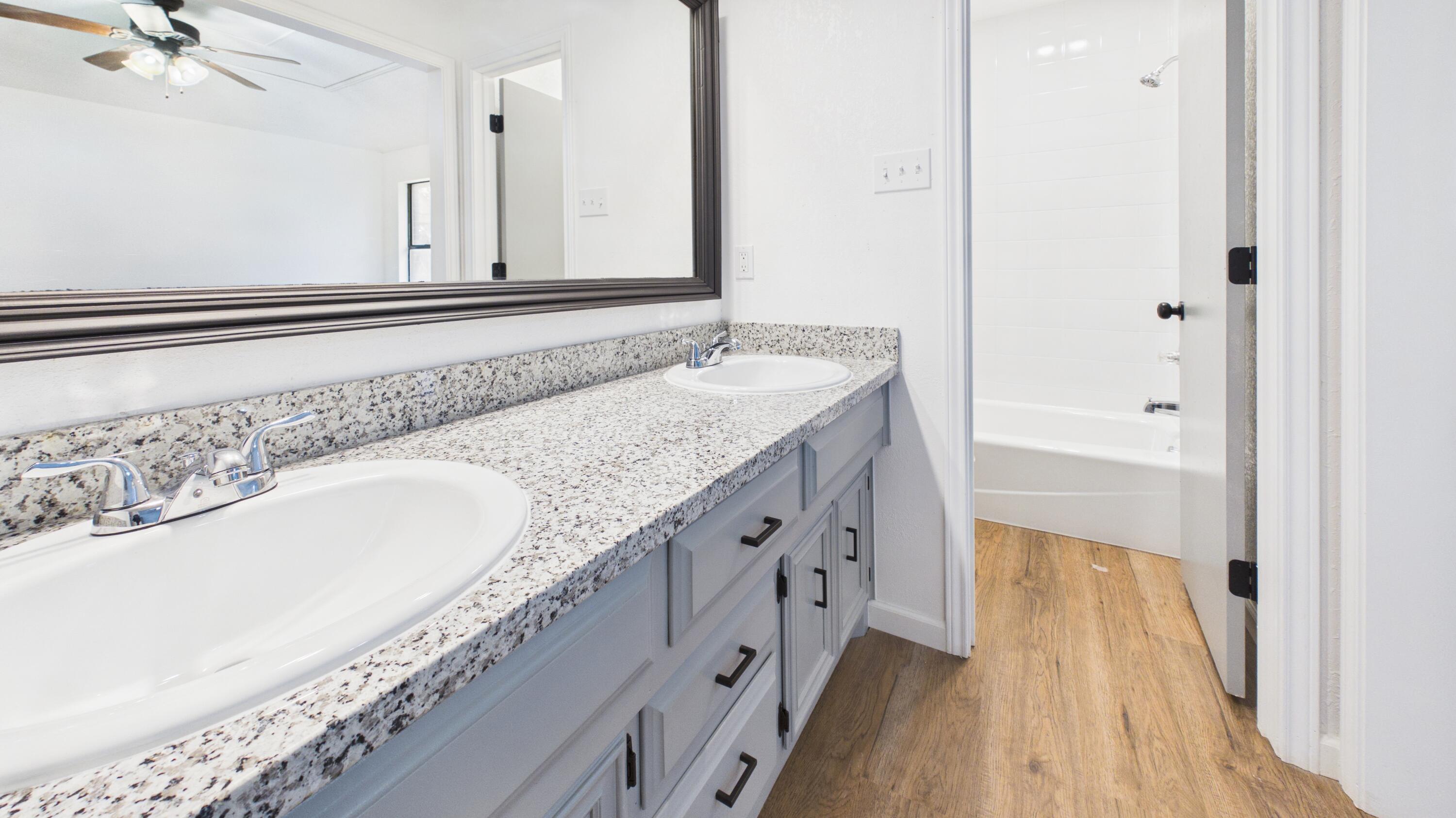 6902 Homestead Avenue Lubbock, TX 79424 - Photo 14 of 17 a bathroom with a granite countertop double vanity sink and mirror