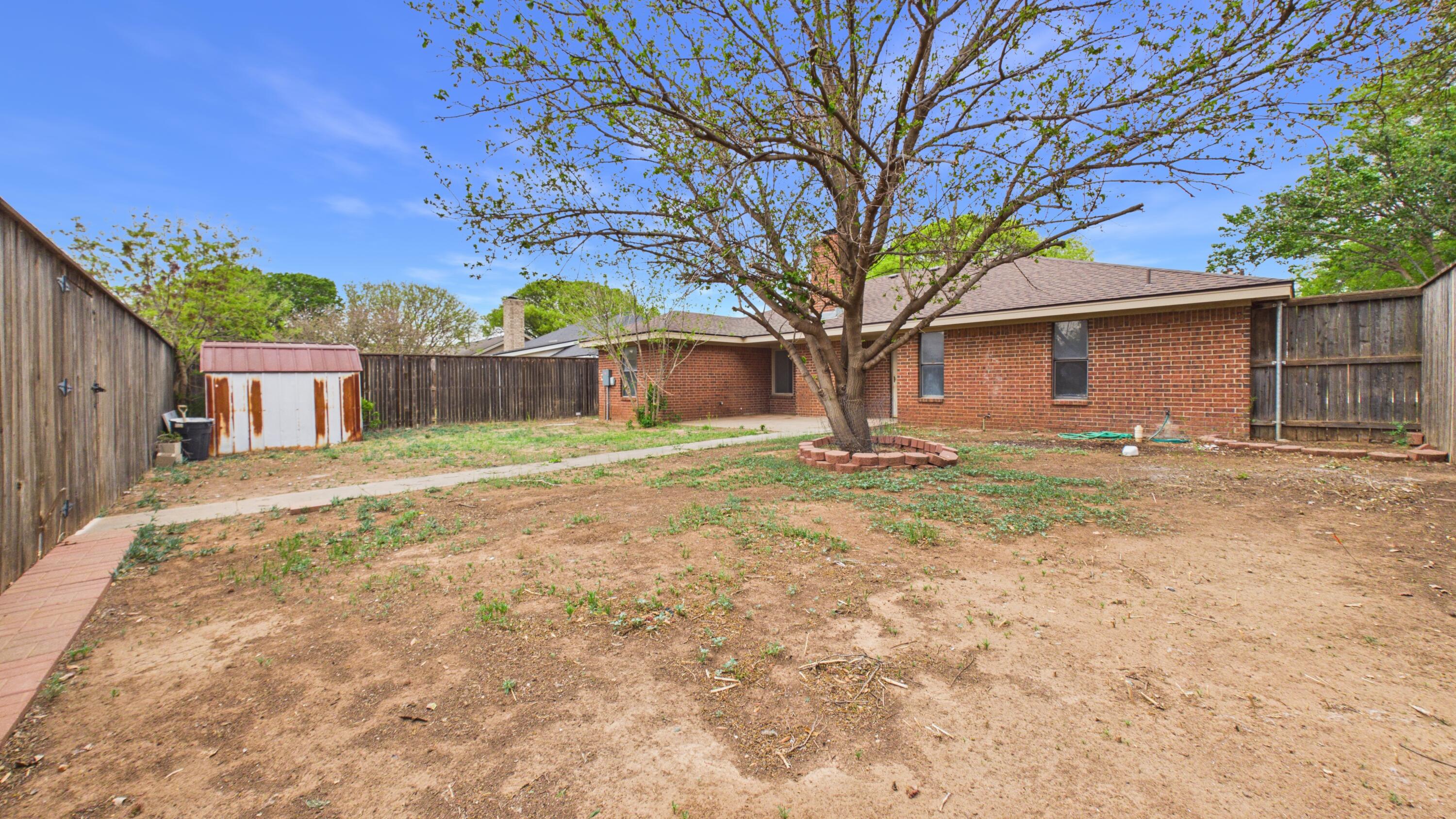 6902 Homestead Avenue Lubbock, TX 79424 - Photo 17 of 17 a backyard of a house with large trees and outdoor seating