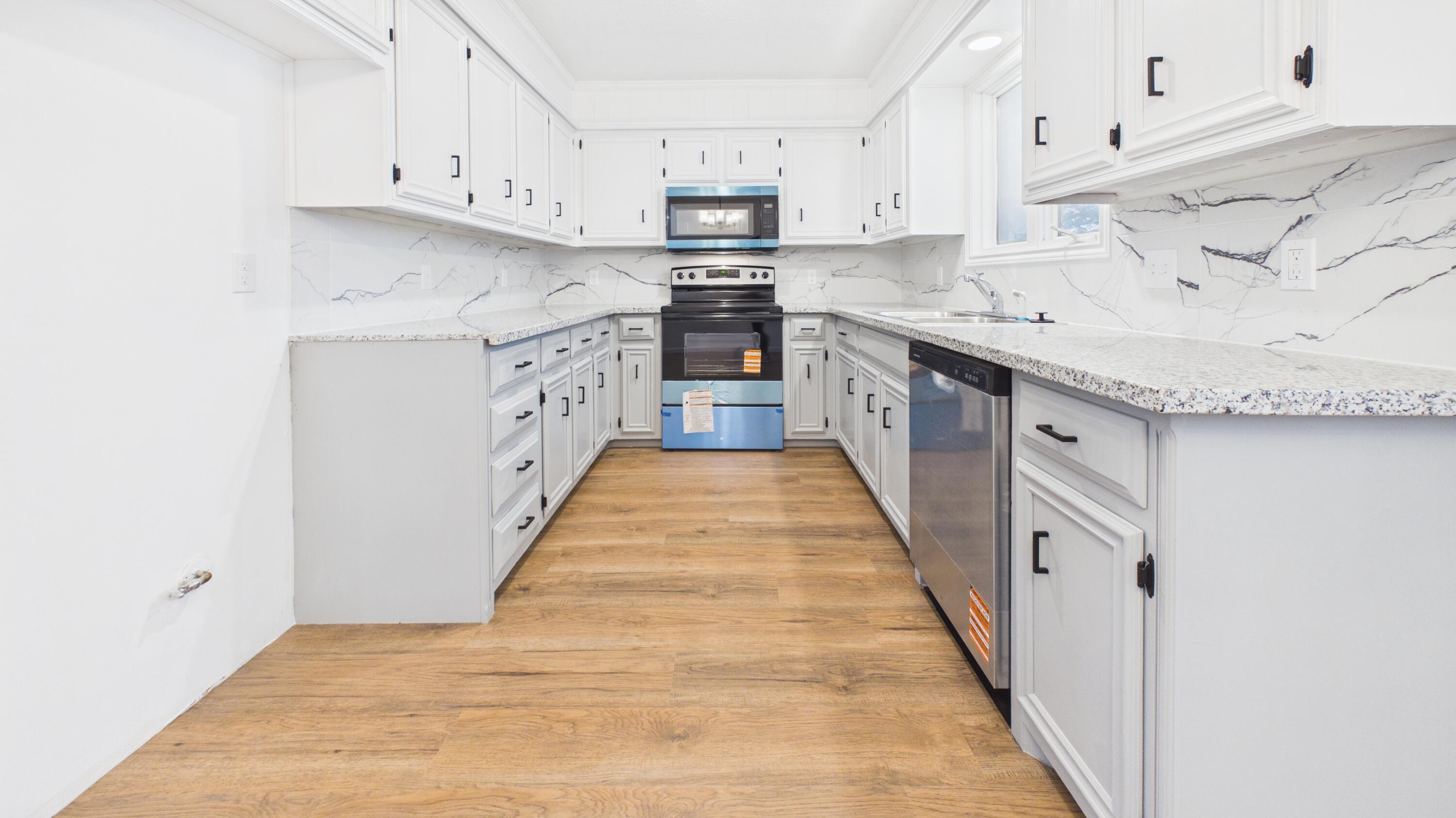 6902 Homestead Avenue Lubbock, TX 79424 - Photo 2 of 17 a kitchen with stainless steel appliances granite countertop lots of white cabinets and a sink