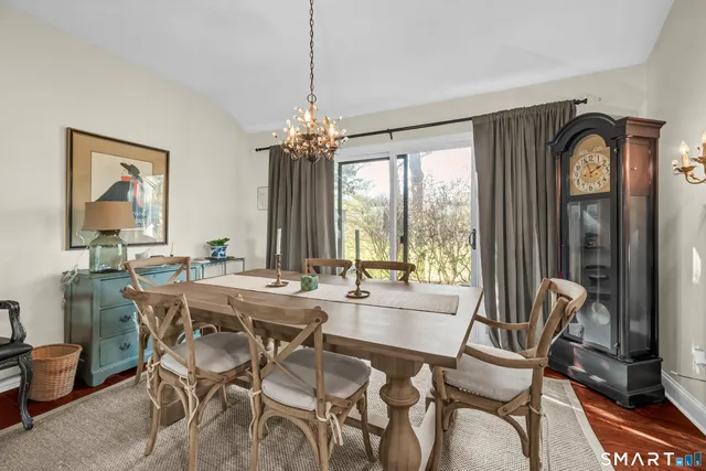 a dining room with furniture a chandelier and window