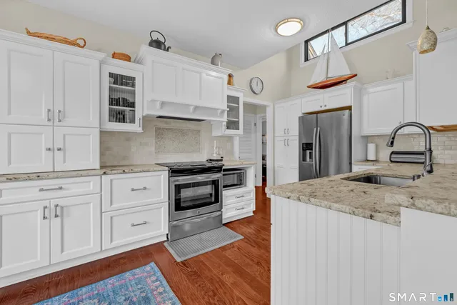 a kitchen with stainless steel appliances granite countertop a stove and cabinets