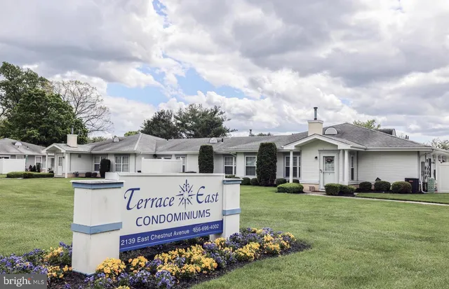 a view of a white house with a big yard and large trees
