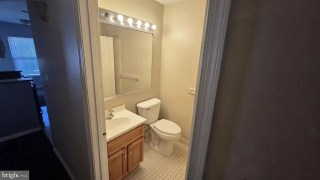 a bathroom with a granite countertop toilet and a sink