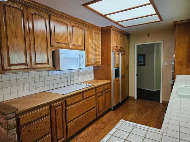 a spacious bathroom with a granite countertop sink a mirror and a bathtub