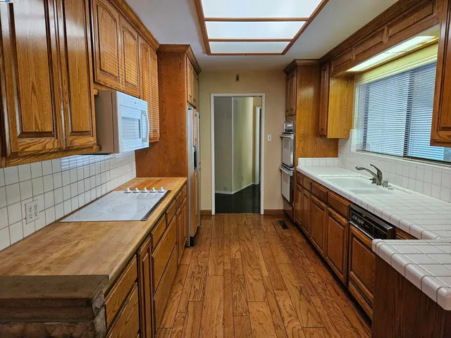 a kitchen with granite countertop wooden cabinets a sink and a stove