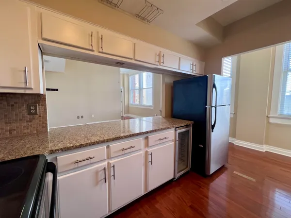 a kitchen with granite countertop wooden cabinets a refrigerator and a sink