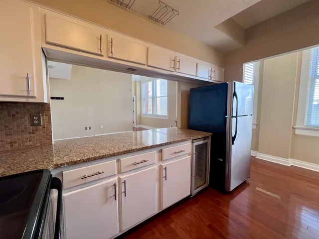 a kitchen with granite countertop wooden cabinets a refrigerator and a sink