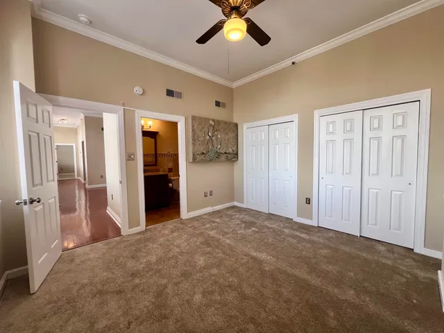 a view of a big room with closet and a chandelier fan