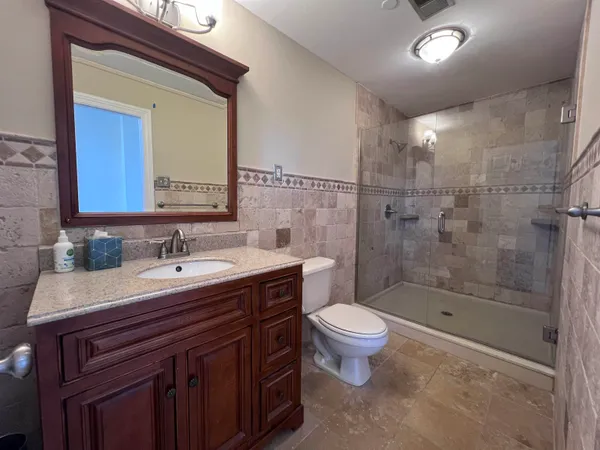 a bathroom with a sink a toilet and shower