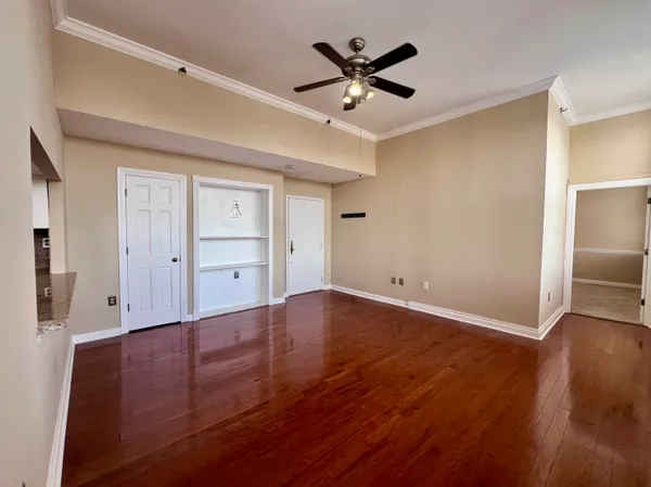 an empty room with wooden floor and windows