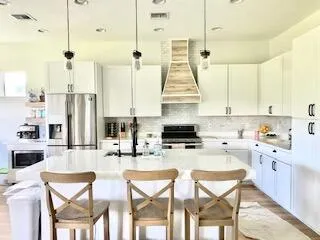 a kitchen with stainless steel appliances a stove a sink and cabinets