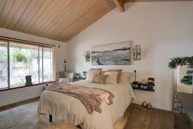 a bedroom with a bed and a large window