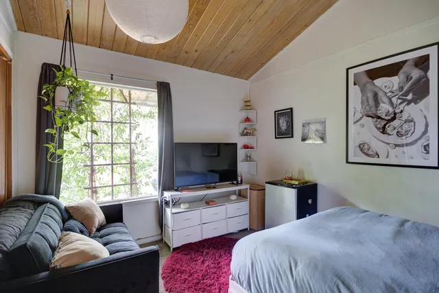 a bedroom with a bed a couch and a window