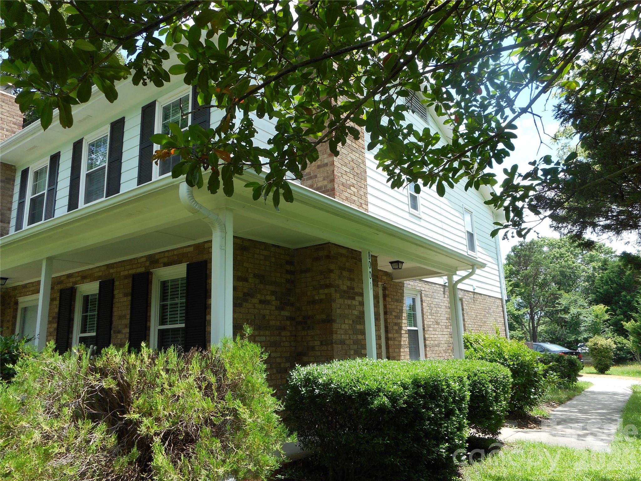 a view of a white house next to a yard