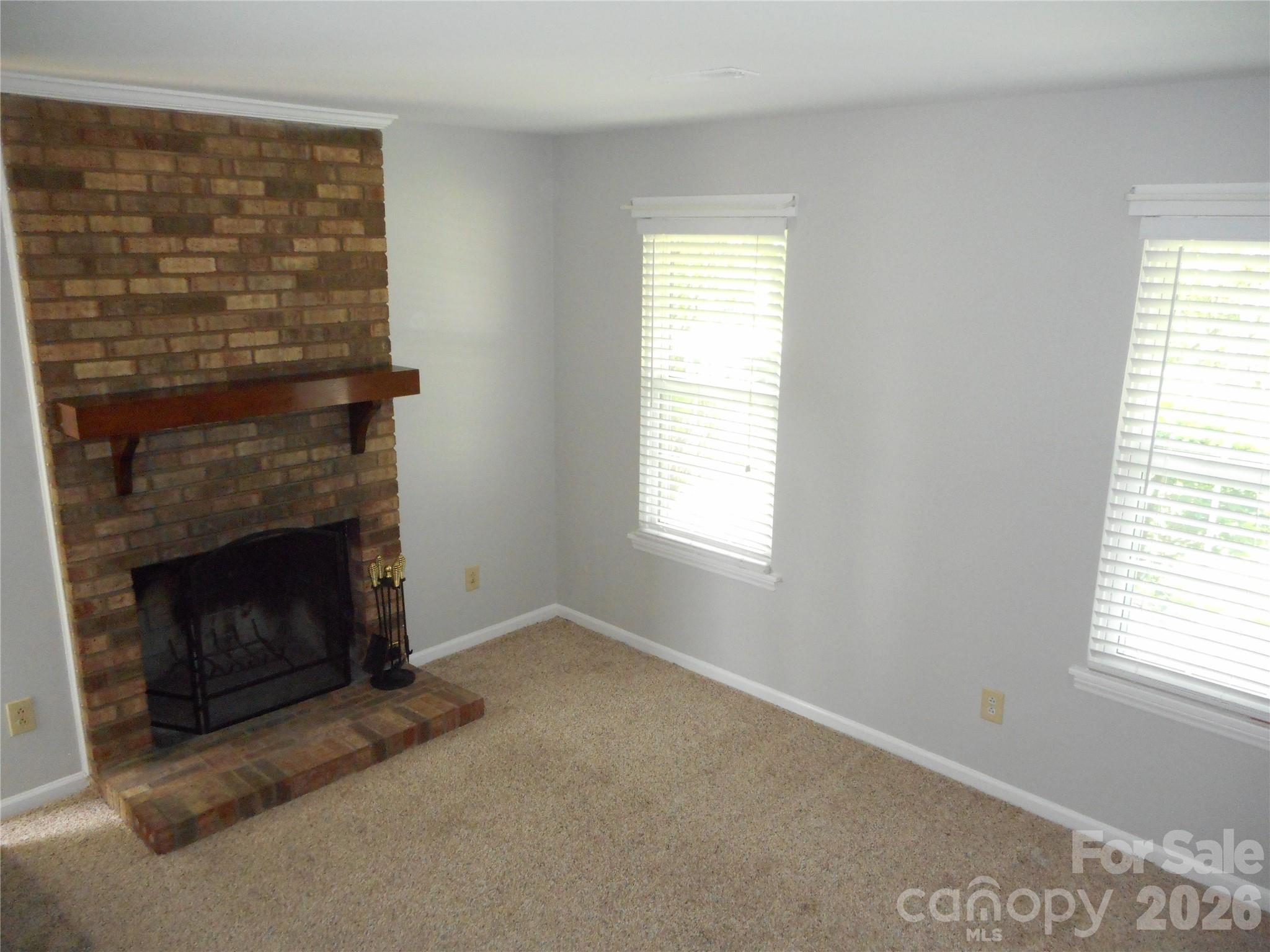 8001 Carmel Road Charlotte, NC 28226 - Photo 7 of 22 a living room with a fireplace and a window