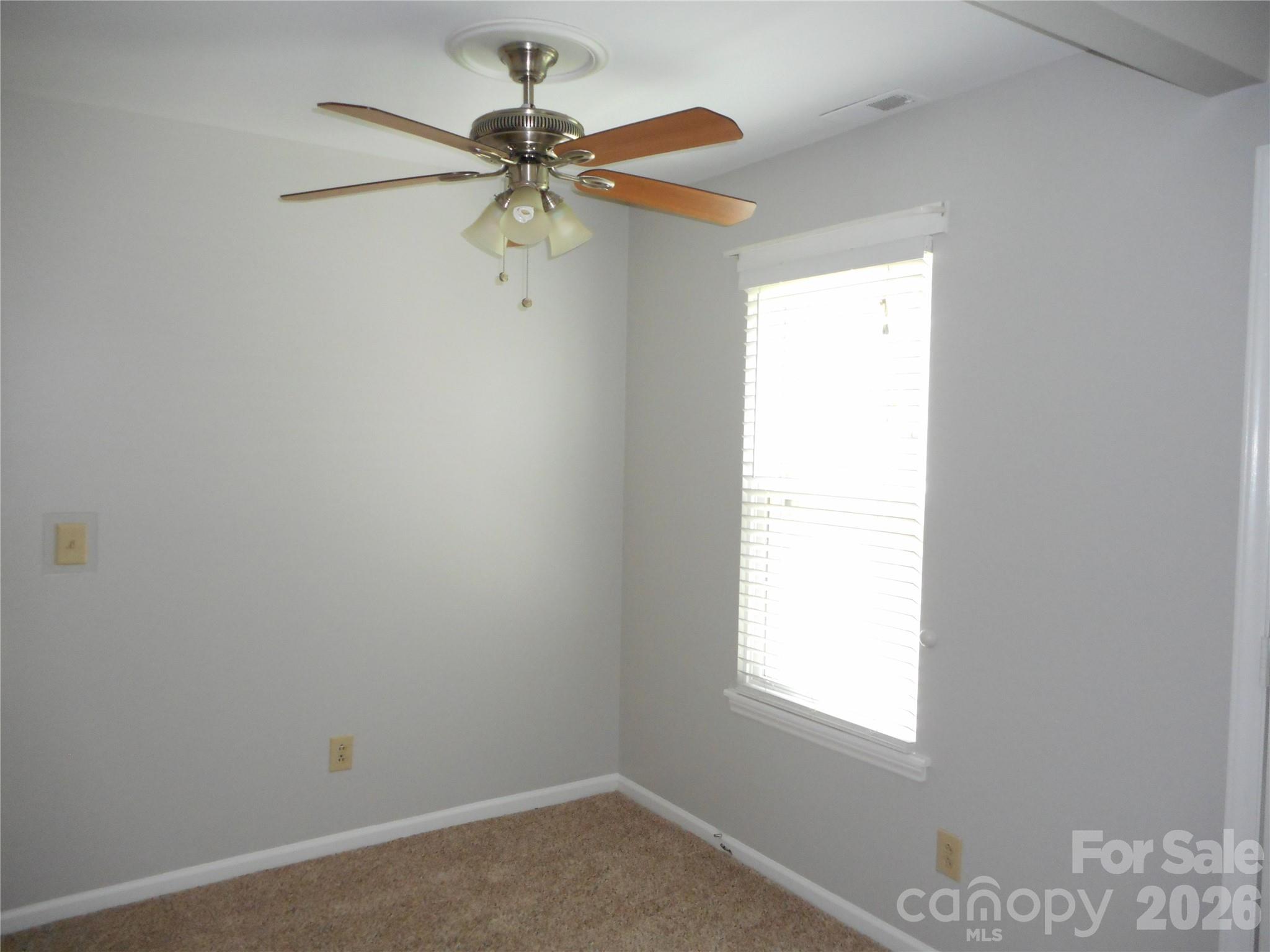 8001 Carmel Road Charlotte, NC 28226 - Photo 8 of 22 an empty room with a window and a fan