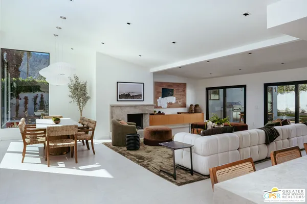 a living room with furniture a fireplace and a table